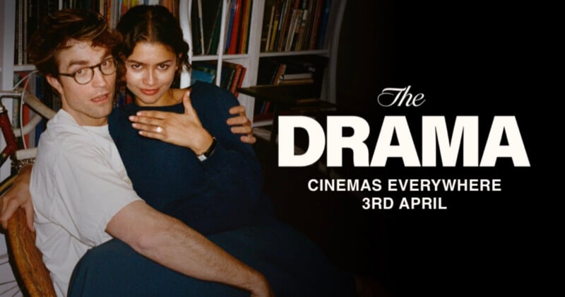 A man and woman sit closely together, smiling, with the woman showing off a ring. Text reads: "The DRAMA. Cinemas everywhere 3rd April." A bookshelf is visible in the background.