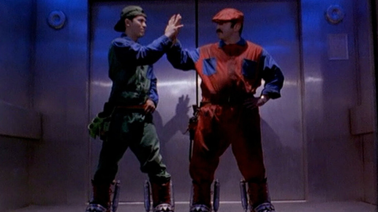 Luigi and Mario high five in an elevator in Super Mario Bros.