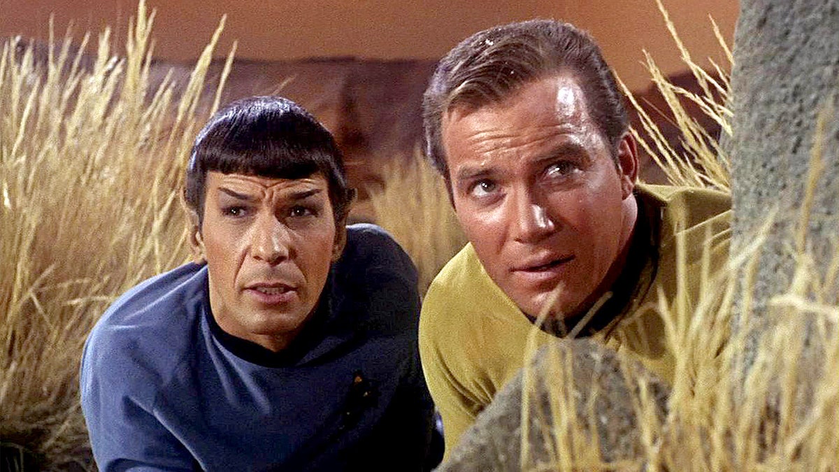 Leonard Nimoy as Mr. Spock and William Shatner as Captain James T. Kirk stand together in a Star Trek scene.
