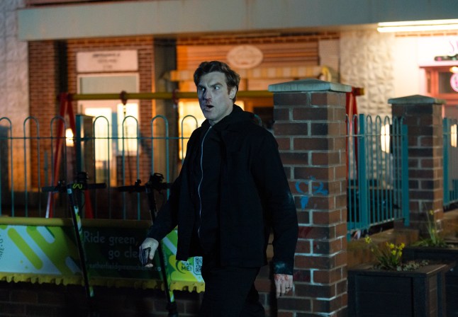 Theo standing in the precinct in Corrie