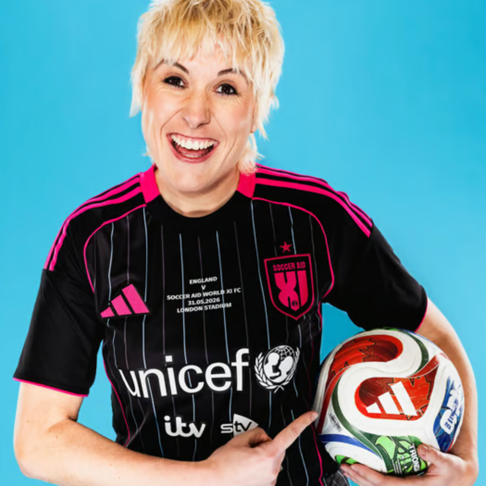 Soccer aid line up person in a black soccer jersey holding a soccer ball