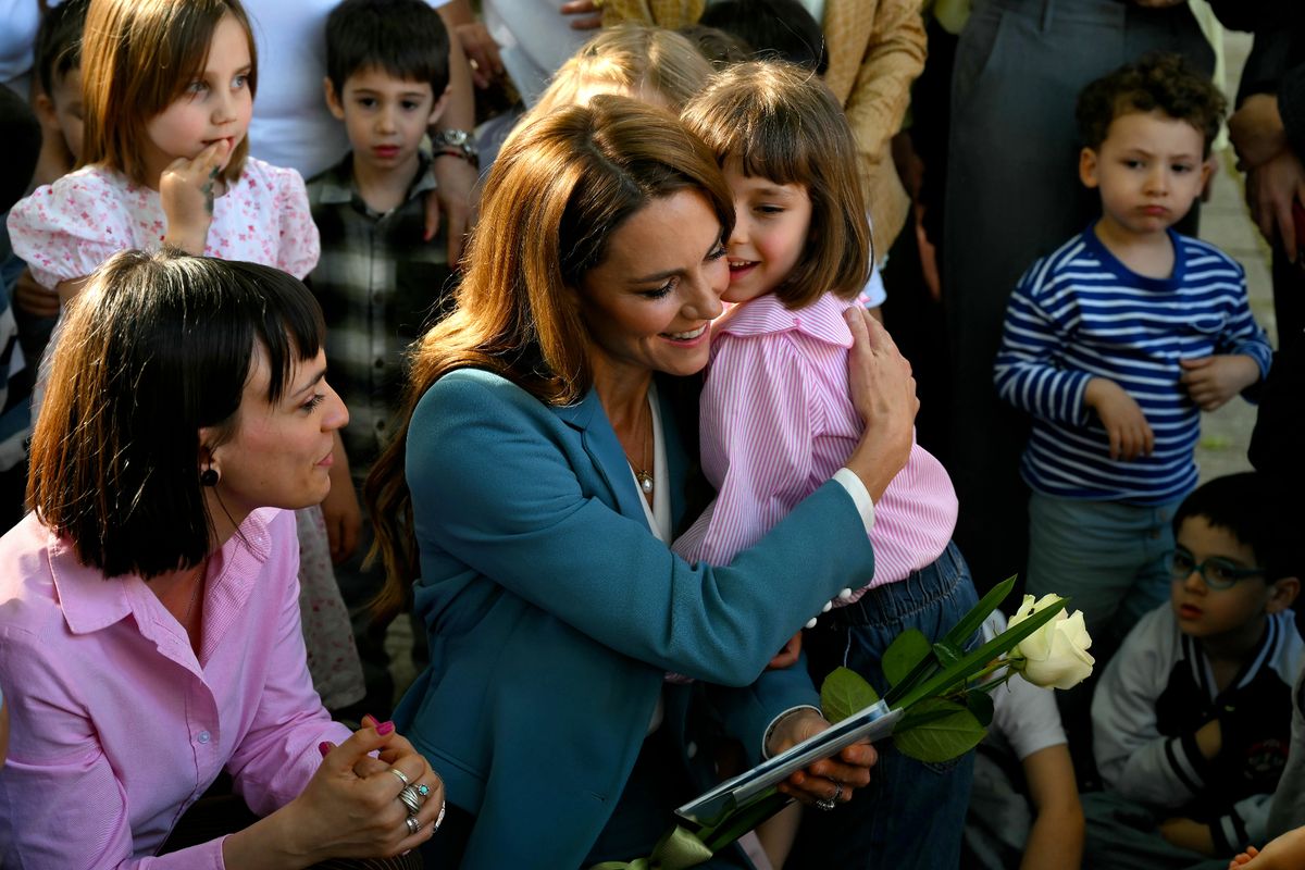Kate hugs a child at the Scuola Comunale d'infanzia Anna Frank