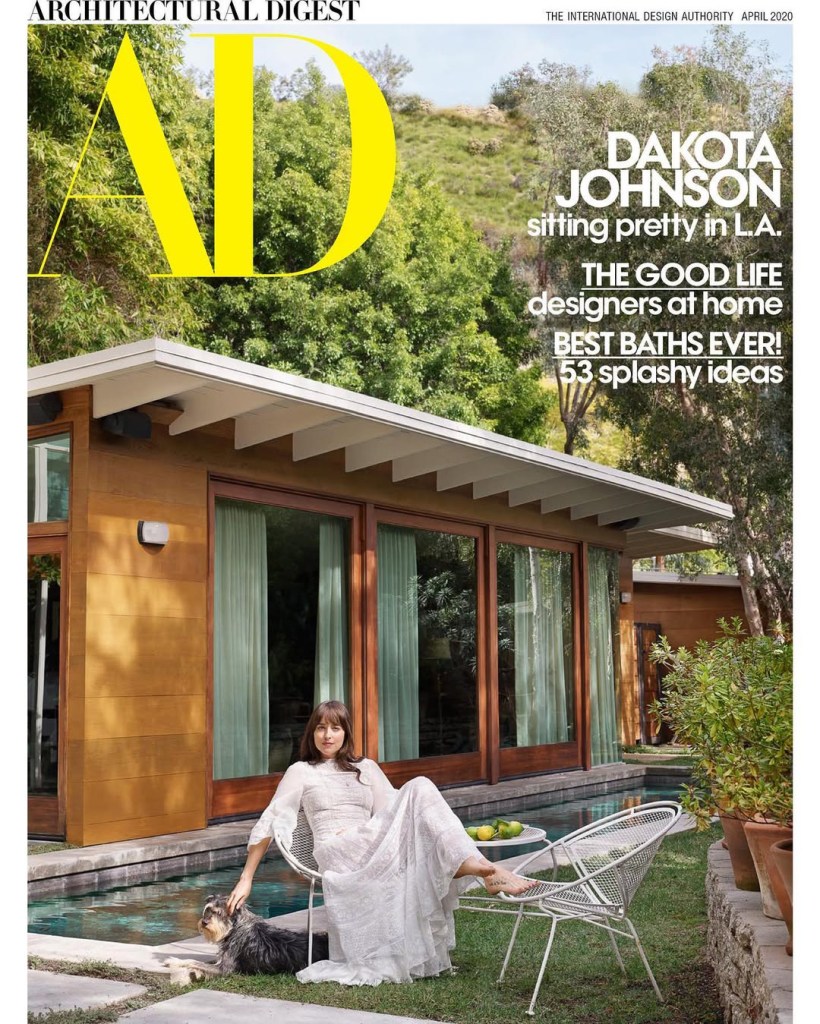 Architectural Digest magazine cover featuring Dakota Johnson sitting by a pool with a dog.