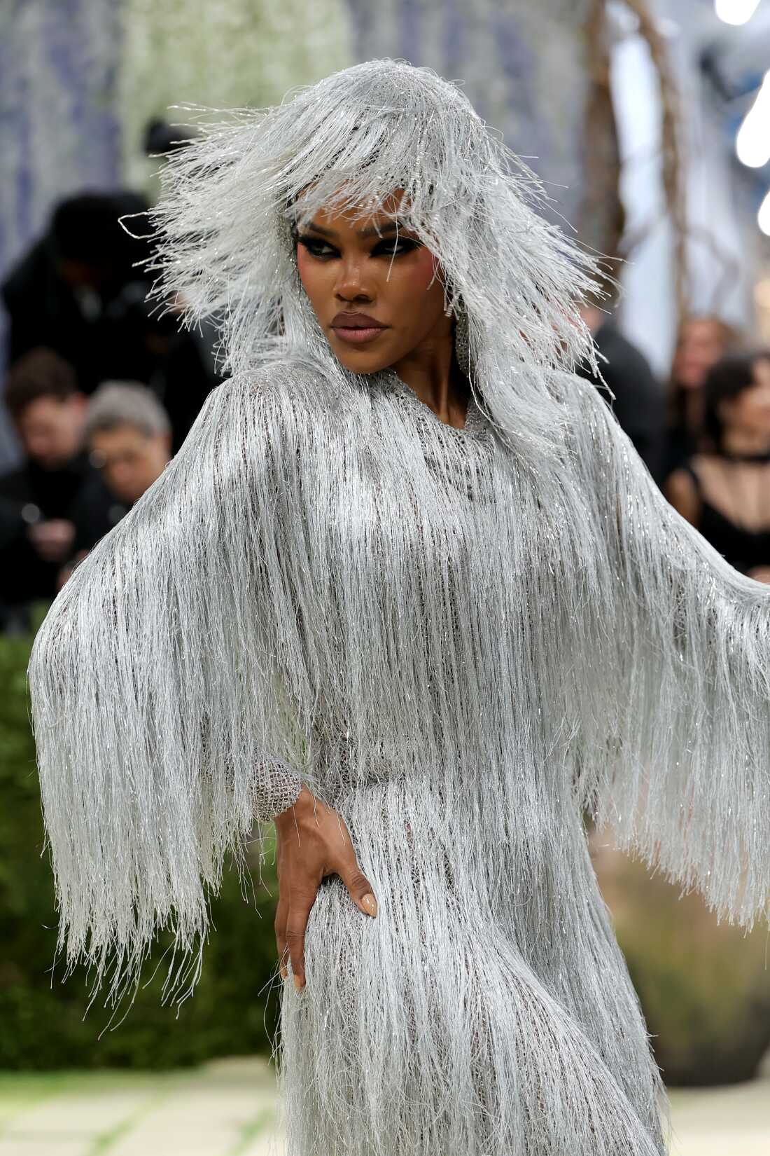 Teyana Taylor attends the 2026 Met Gala. She is wearing head to toe silver fringe and is photographed turning around.