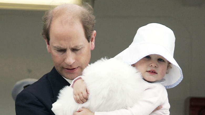 Young Lady Louise Windsor being held by her dad in 2003
