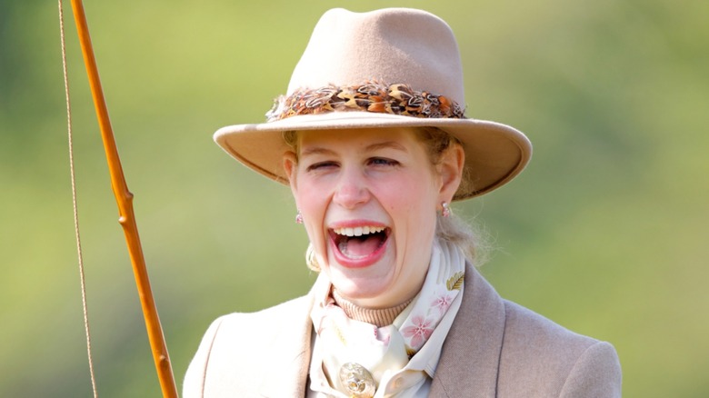 Lady Louise Windsor laughing while taking part in carriage driving in 2023