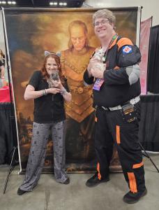 Ghostbuster in costume holds white kitten Marshmallow at PurrCon inside Indianapolis PopCon convention