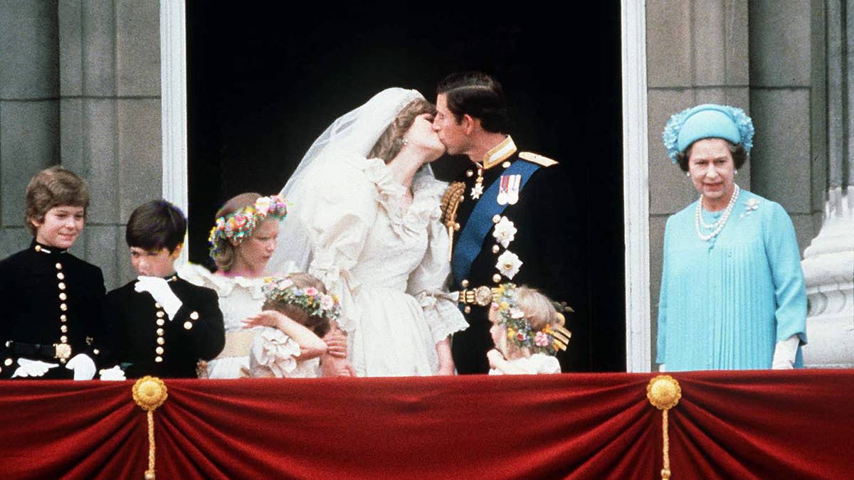 LONDON, UNITED KINGDOM - JULY 29: Prince Charles And Princess Diana Kissing On The Balcony Of Buckingham Palace On Their Wedding Day. (l To R) Lord Nicholas Windsor, Edward Van Cutsem, Sarah Jane Gaselee, Catherine Cameron, Princess Diana, Prince Charles, Clementine Hambro And Queen Elizabeth II. The Princess Is Wearing A Wedding Dress Designed By David And Elizabeth Emanuel. (Photo by Tim Graham Photo Library via Getty Images)Tim Graham Photo Library via Getty Images