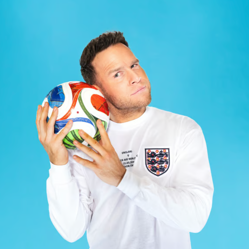 Soccer aid line up person holding a colorful soccer ball against a blue background