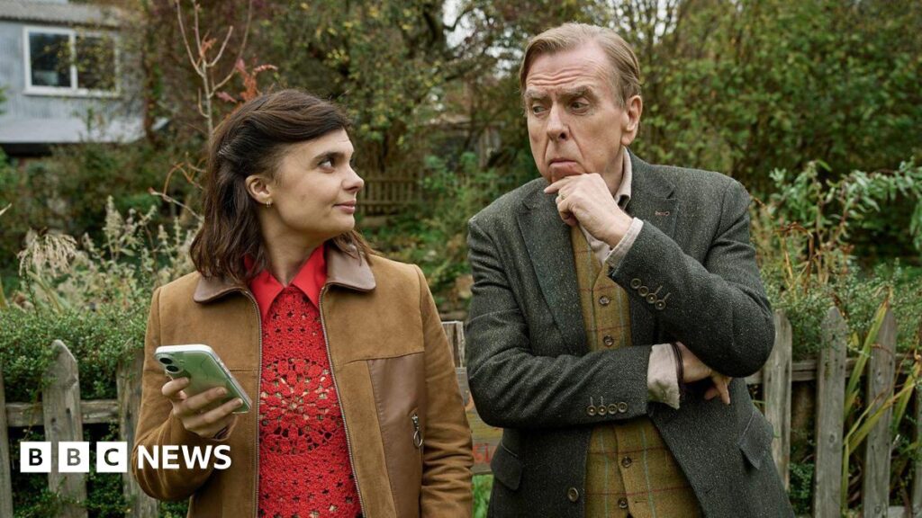 BBC Death Valley creator says TV crime dramas don’t have to be ‘miserable’ Gwyneth Keyworth and Timothy Spall as their Death Valley characters John and Janey. They look at each other and stand in front of a garden fence.