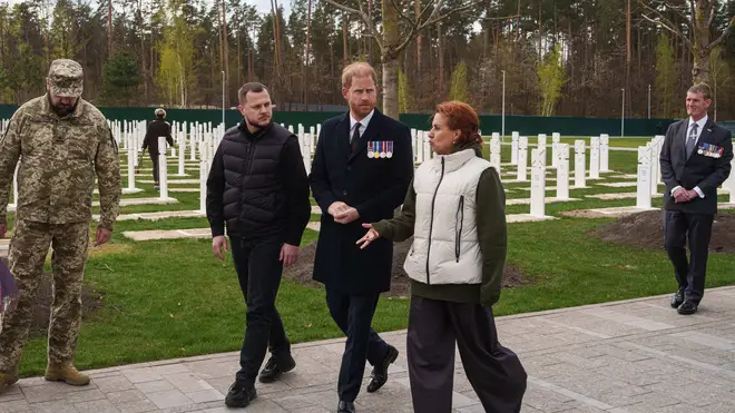 Britain's Prince Harry, center, and Ukraine Veteran's Minister Natalia Kalmykova, right, walk at a military cemetery near Kyiv, Ukraine, on Friday, April 24, 2026. (AP Photo/Evgeniy Maloletka)
