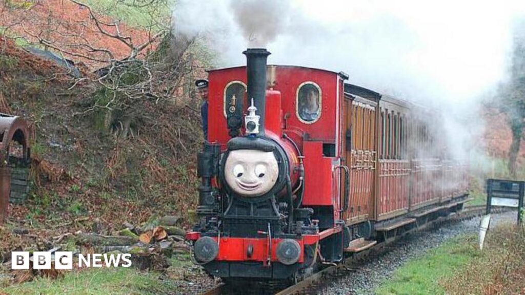 A red train is seen climbing through the woods on the approach to Nant Gwernol with a Tywyn - Nant Gwernol service. April 2004