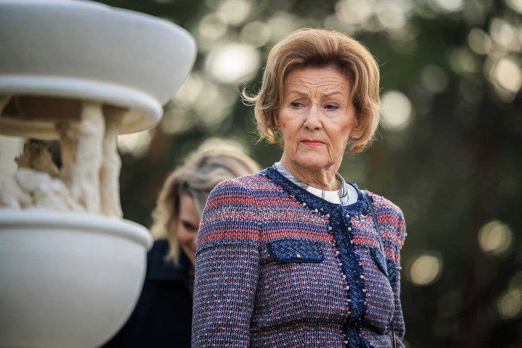 Queen Sonja next to a stone fountain