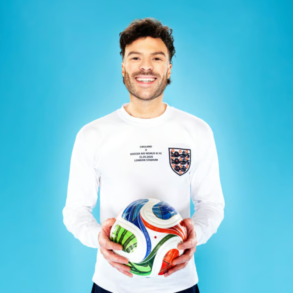 Soccer aid line up a person holding a colorful soccer ball wearing a white longsleeve shirt
