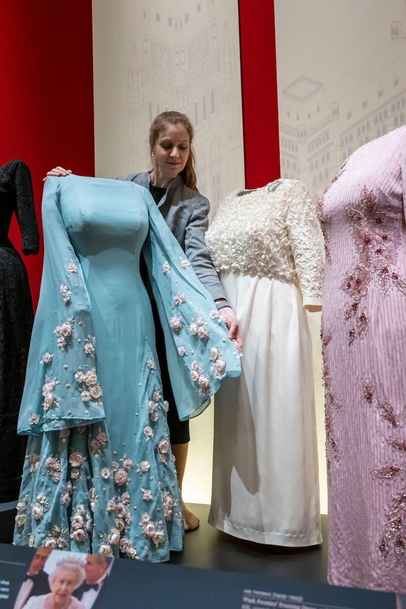 A curator with Queen Elizabeth II’s “Cherry Blossom” evening gown