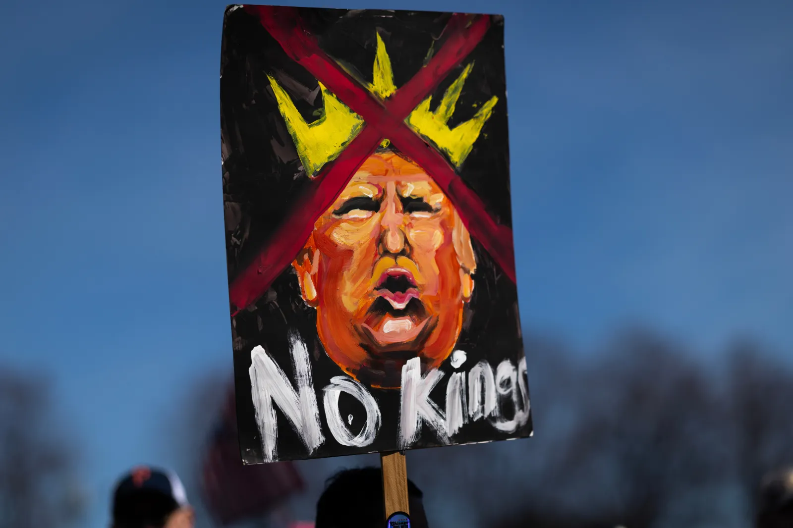 A "No Kings" sign is held up as demonstrators gather downtown in Grant Park for a No Kings rally and march on March 28, 2026 in Chicago, Illinois.