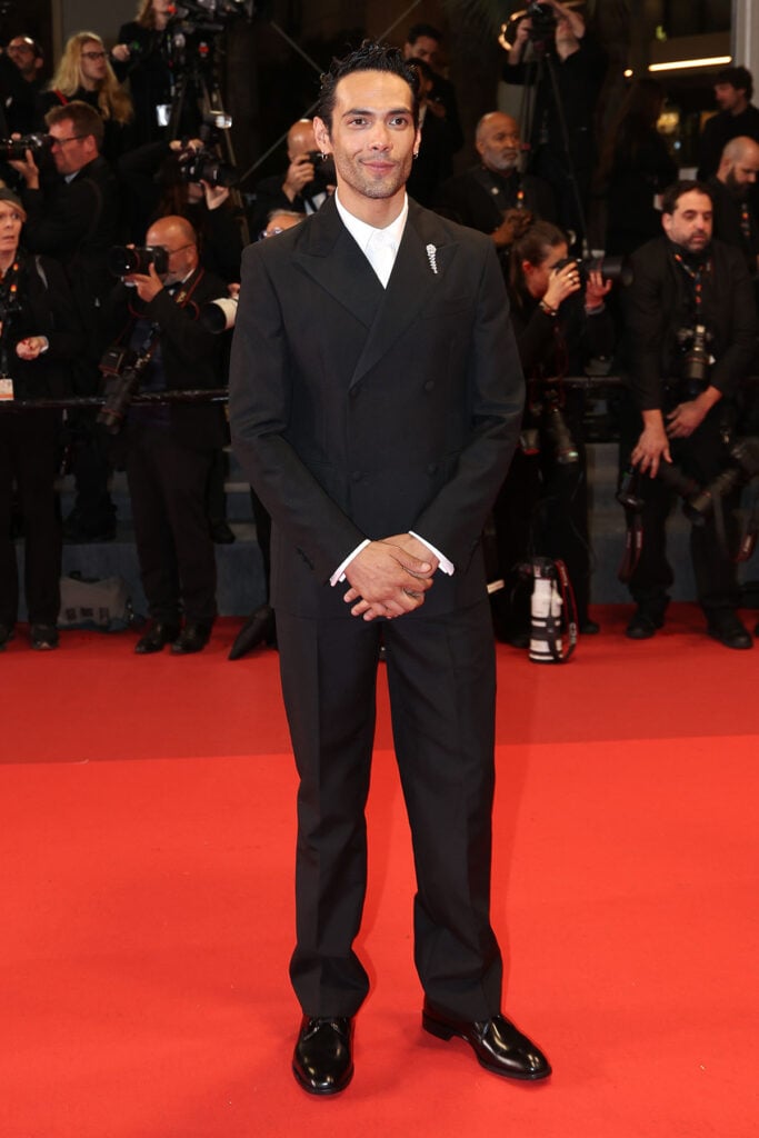 Diego Calva wearing black tailoring from Prada with a Marli brooch at the Her Private Hell Cannes Film Festival premiere.