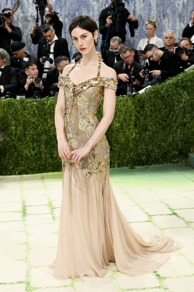 Gracie Abrams wearing a gold and blush Chanel embellished chiffon gown at the 2026 Met Gala