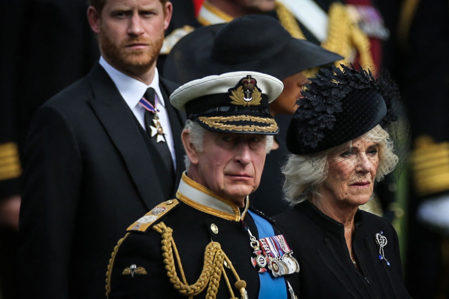 King Charles III (L), Britain's Camilla, Queen Consort and Britain's Prince Harry, Duke of Sussex look at members of the Bearer Party transferring the coffin of Queen Elizabeth II, draped in the Royal Standard, form the State Gun Carriage of the Royal Navy into the State Hearse at Wellington Arch in London