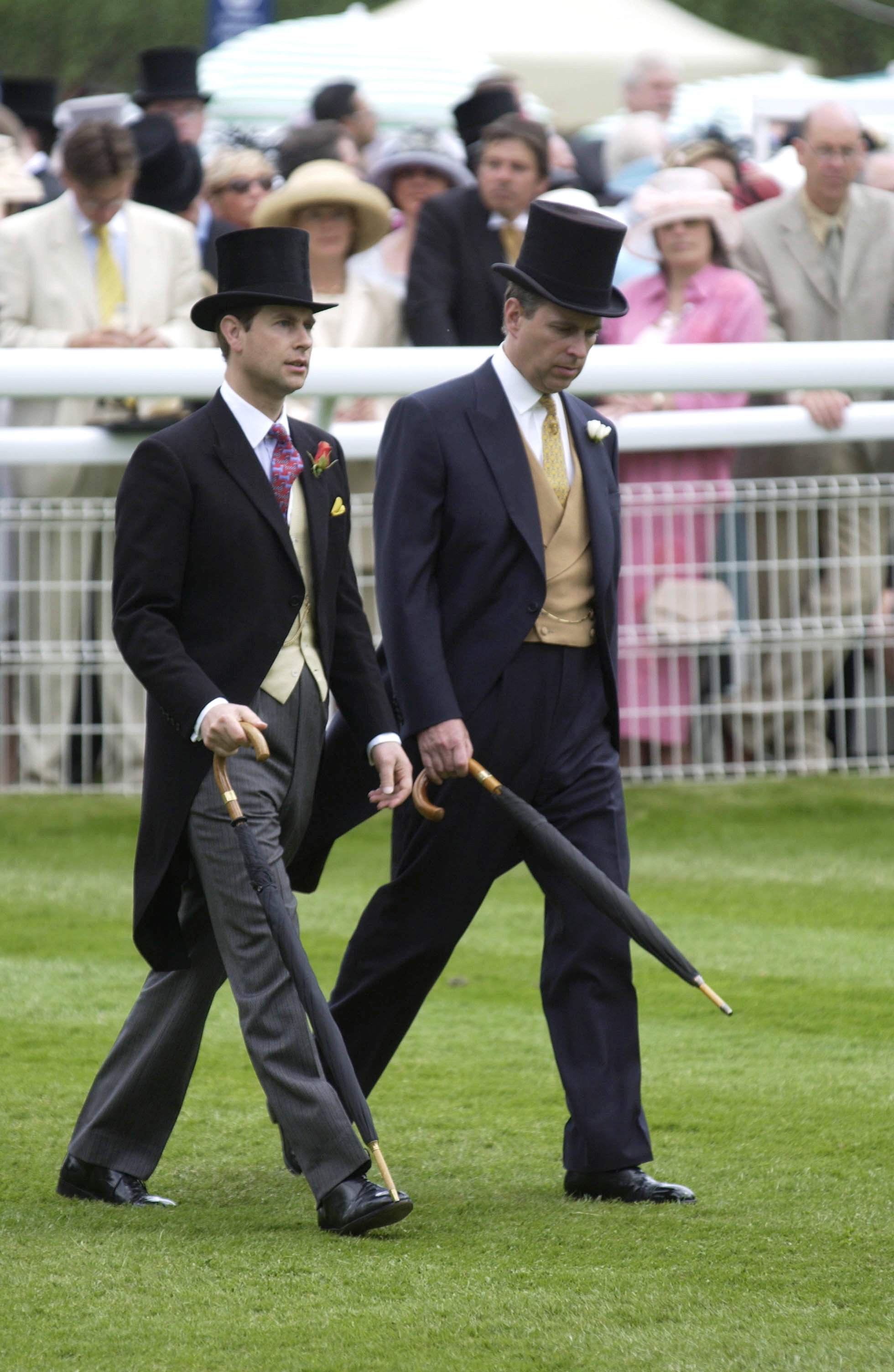 Prince Edward and Prince Andrew walking next to each other in top hats at Ascot