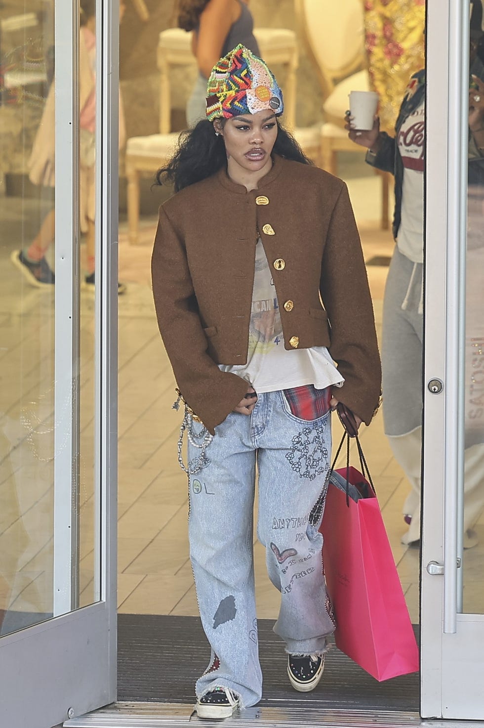 Individual exiting a store with a shopping bag.