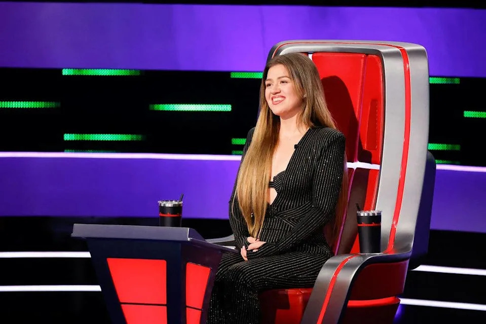 photo of kelly clarkson sitting in red chair on the voice