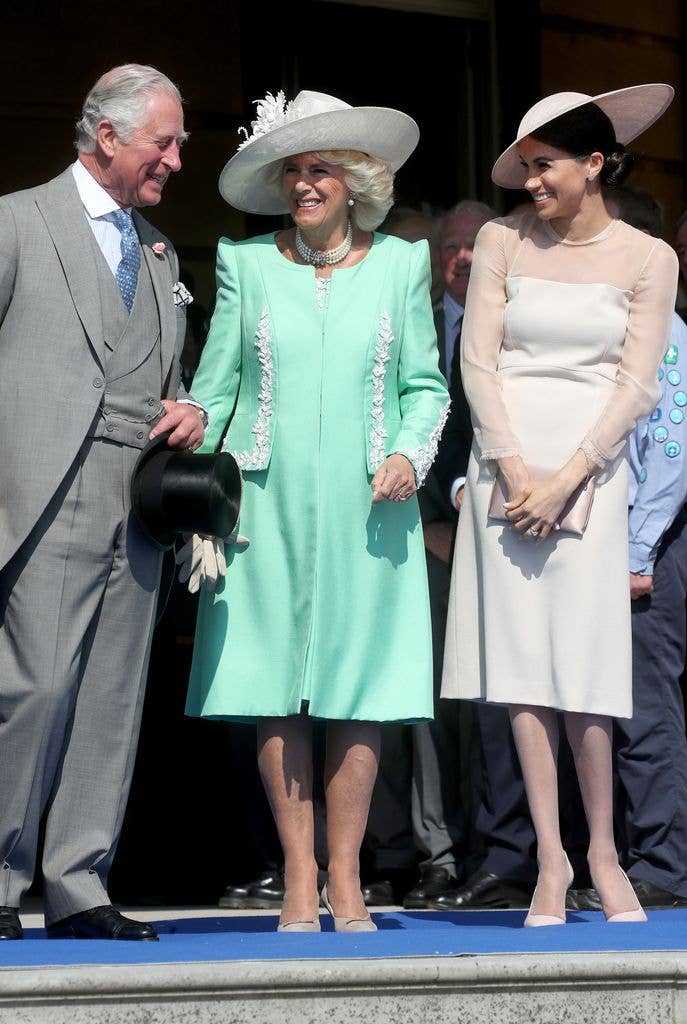 Meghan Markle laughing with King Charles and Queen Consort Camilla