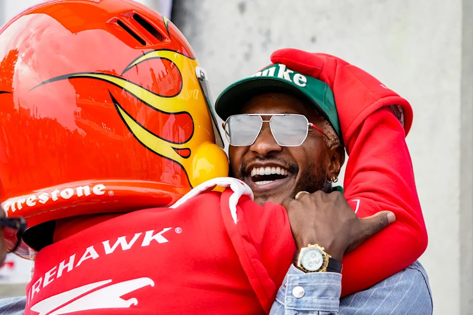 The Fire Hawk hugs TV host Scott Evans on Sunday, May 24, 2026, during the 110th running of the Indianapolis 500 at Indianapolis Motor Speedway.