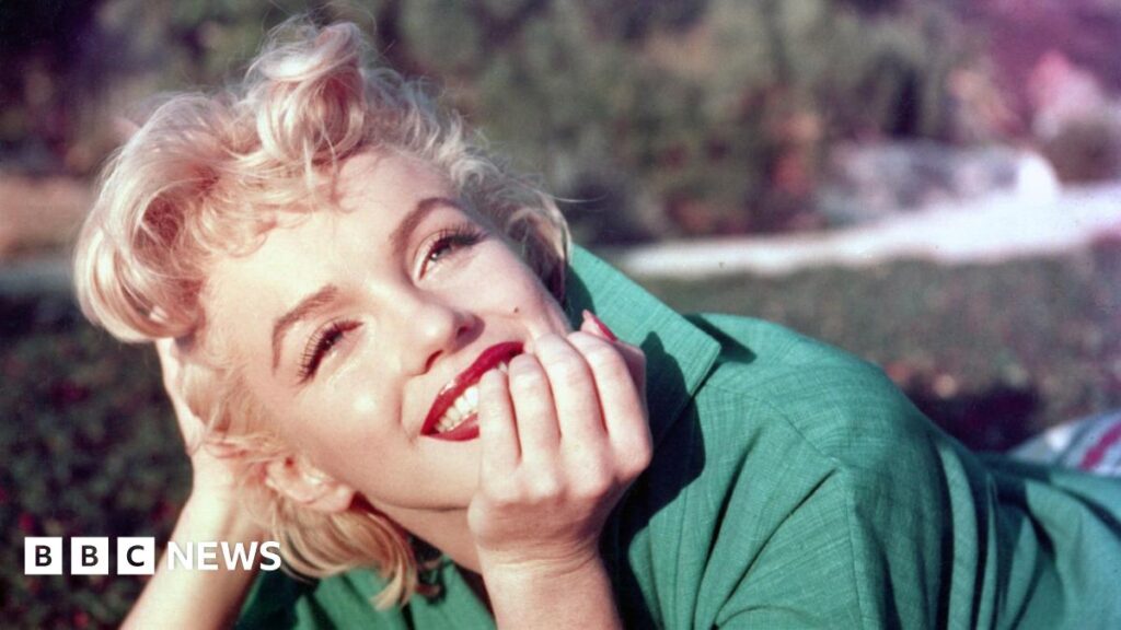 A woman, Marilyn Monroe, wearing a green top.