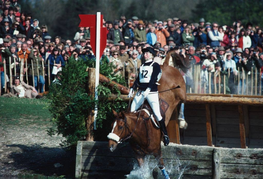 Princess Anne leaning back on her horse Stevie B as they go over a water jump in 1982