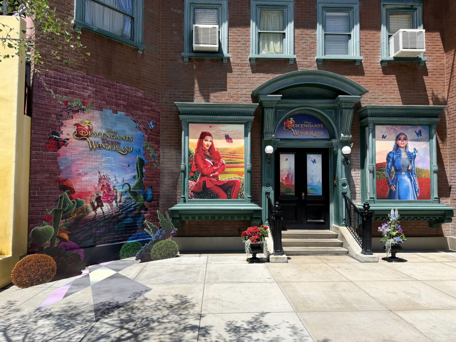 ‘Descendants: Wicked Wonderland’ Display Installed at Disney California Adventure The display spans all across the brick facade, as well as the doors and windows of the building.