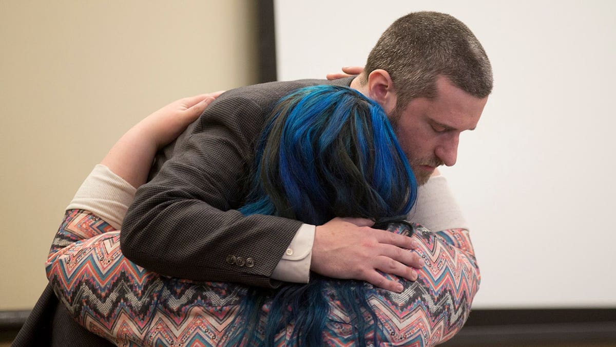 Dustin Diamond embracing his fiancee Amanda Schutz in a courthouse