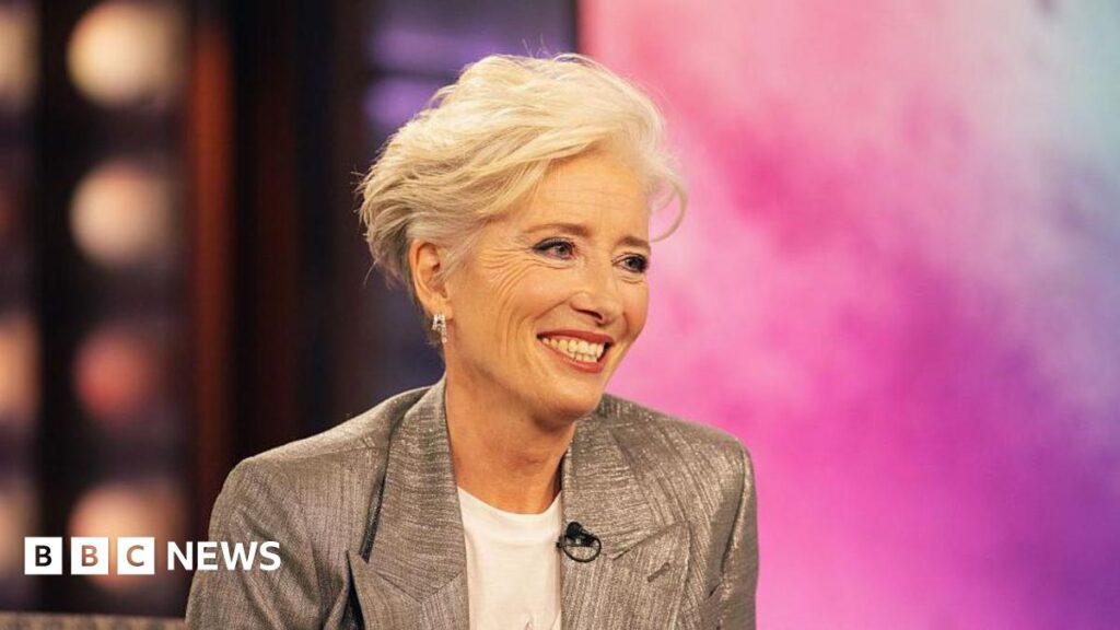 Hay Festival: Actress Emma Thompson gets Medal for Drama award Emma Thompson sat on stage on the Kelly Clarkson show. She is smiling whilst wearing a white t-shirt and silver blazer.