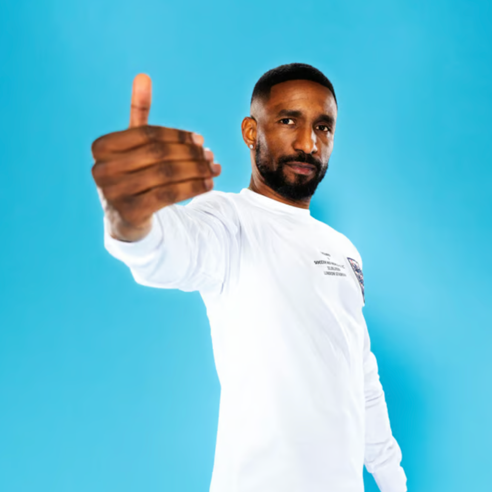Soccer aid line up person giving a thumbs up gesture against a blue background