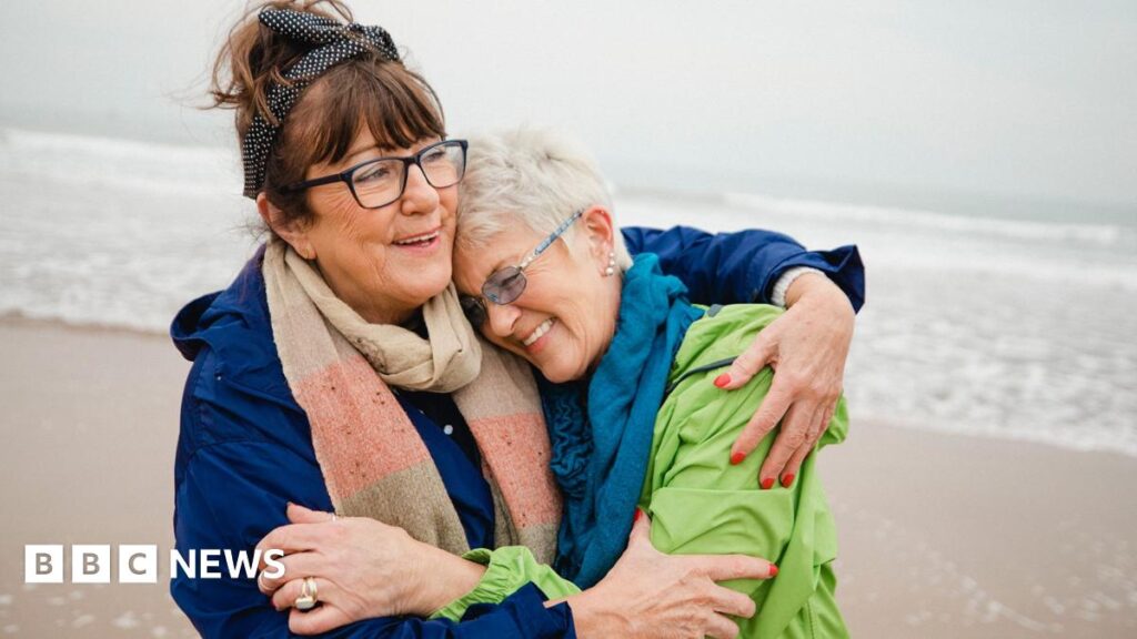 Two women hugung each other on a beach