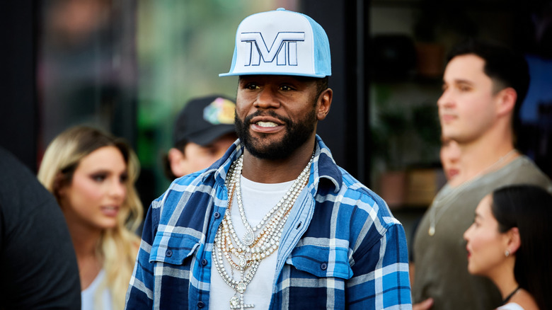 Floyd Mayweather walking on a busy street.