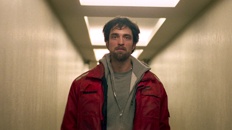 Connie walking down a hallway in a red jacket in Good Time