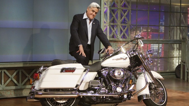 Jay Leno standing beside a Harley-Davidson motorcycle on 