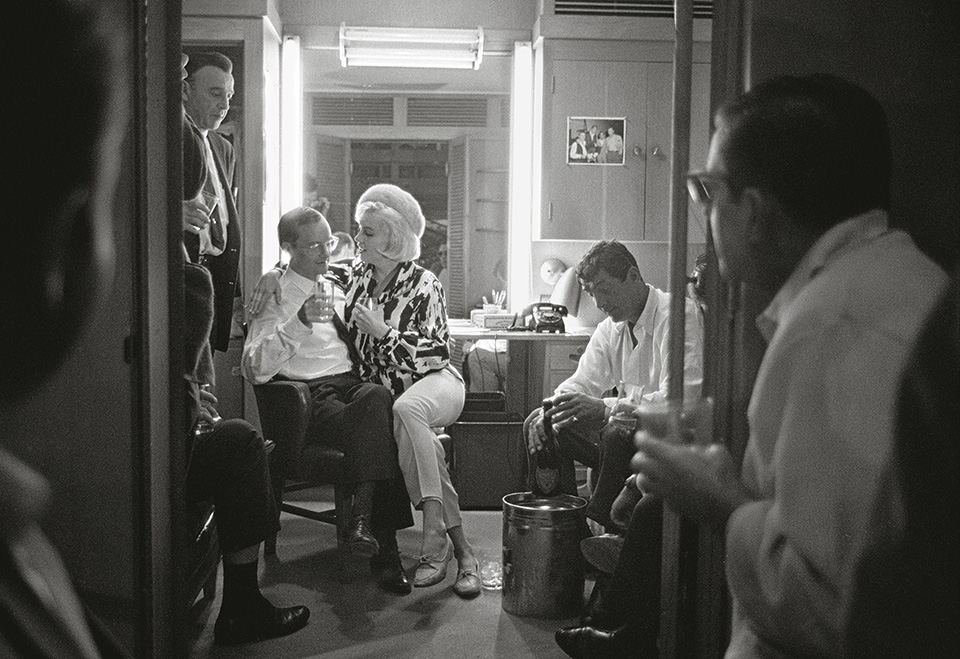 Monroe celebrates her 36th birthday on the set of “Something’s Got to Give” with co-stars Wally Cox (l.), Dean Martin (r.), and Martin’s driver (standing). 