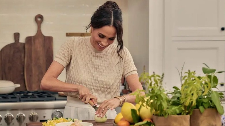 Meghan Markle wearing a beige sweater and matching pants on her Netflix cooking show, 