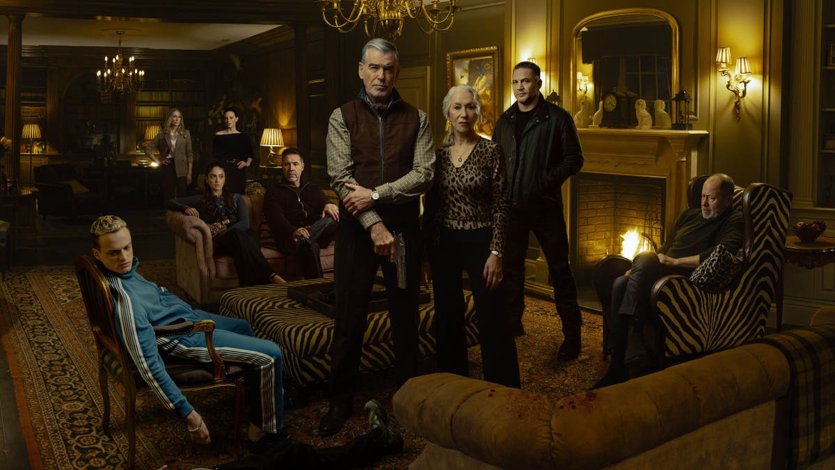 Anson Boon as Eddie Harrigan and cast members seated in a living room scene from Mobland season 1