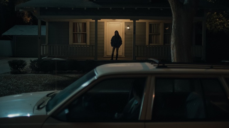 Nikki standing on the porch in Obsession