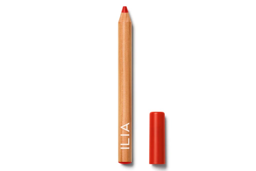 Red Ilia lip pencil with cap beside it.