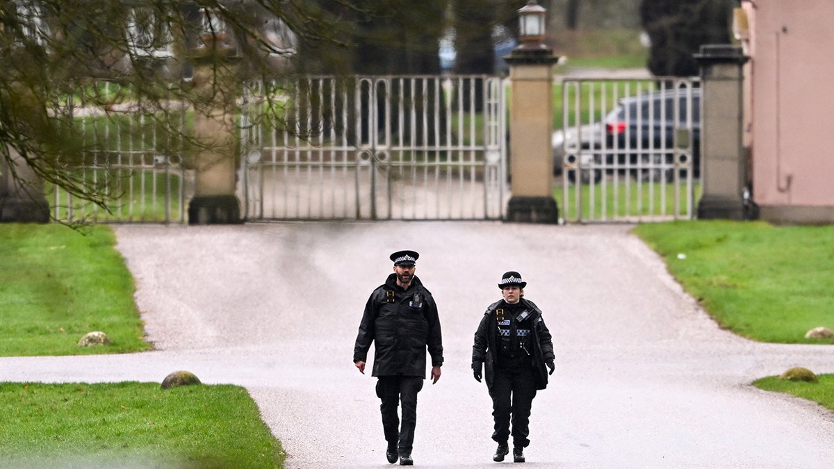 Police officers walking near the entrance to the Royal Lodge in Windsor