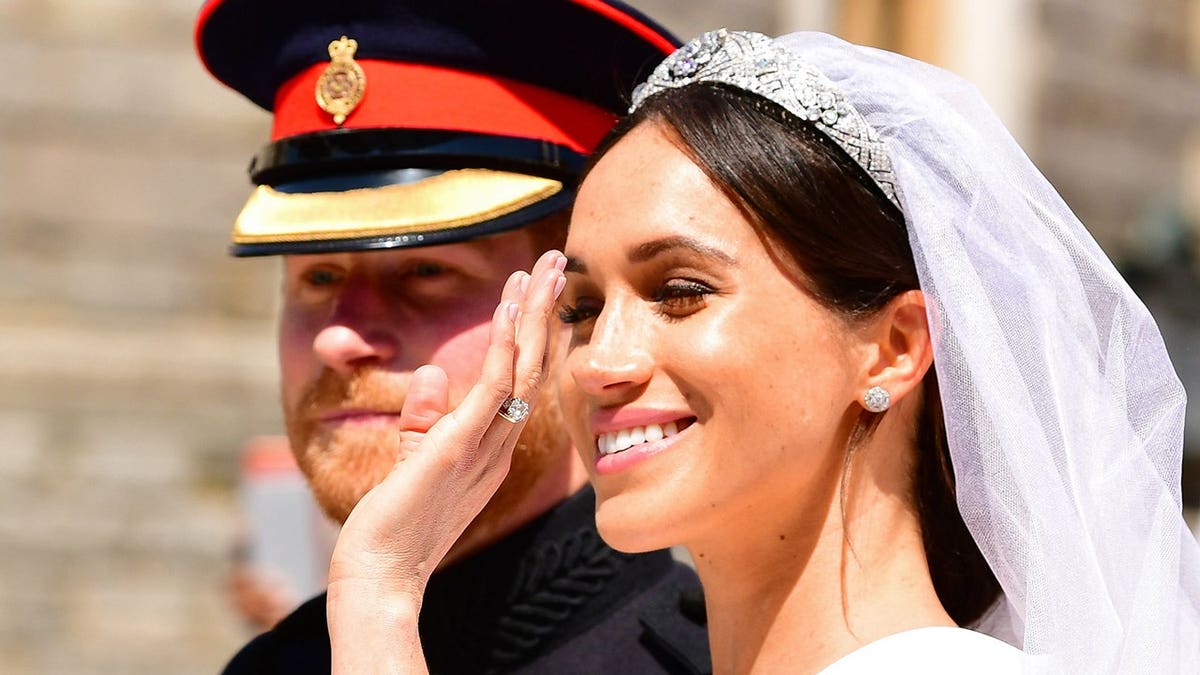 Prince Harry and Meghan Markle riding in a carriage leaving Windsor Castle