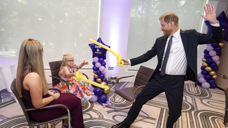 Prince Harry, Duke of Sussex play fights using swords made from modelling balloons with nine-year-old Gwen Foster, recipient of Inspirational Child 7-11 award, at the annual WellChild Awards 2025