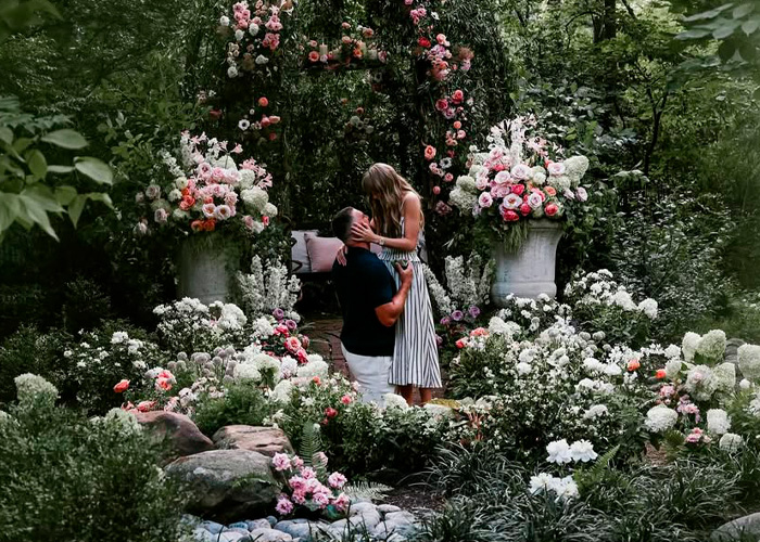 Couple surrounded by flowers in garden setting for Taylor Swift wedding plans