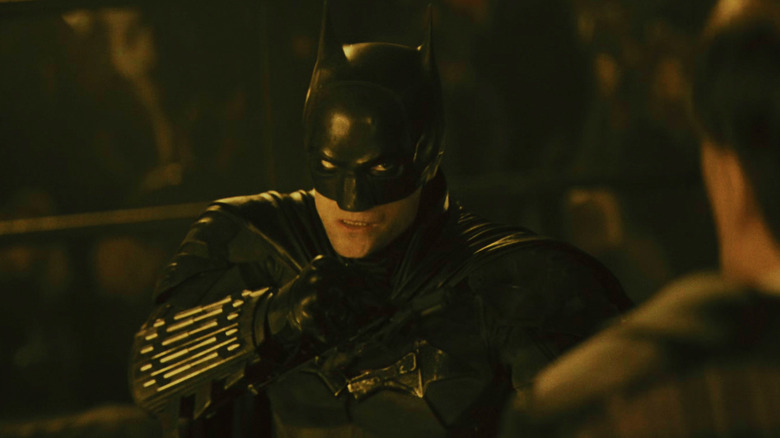 Robert Pattinson's Batman stands with his fists raised in the Iceberg Lounge in The Batman