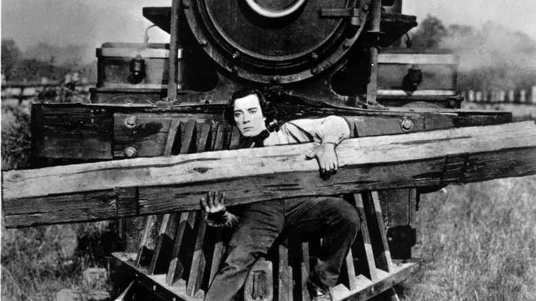 Johnny Gray riding a Locomotive while carrying a railroad tie in 