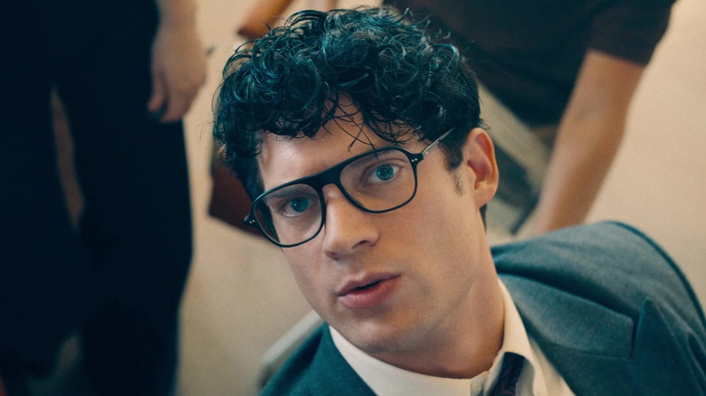 David Corenswet as Clark Kent looking up at the TV from his desk in Superman